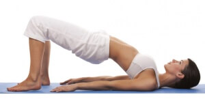 pretty brunette is exercising yoga on white background